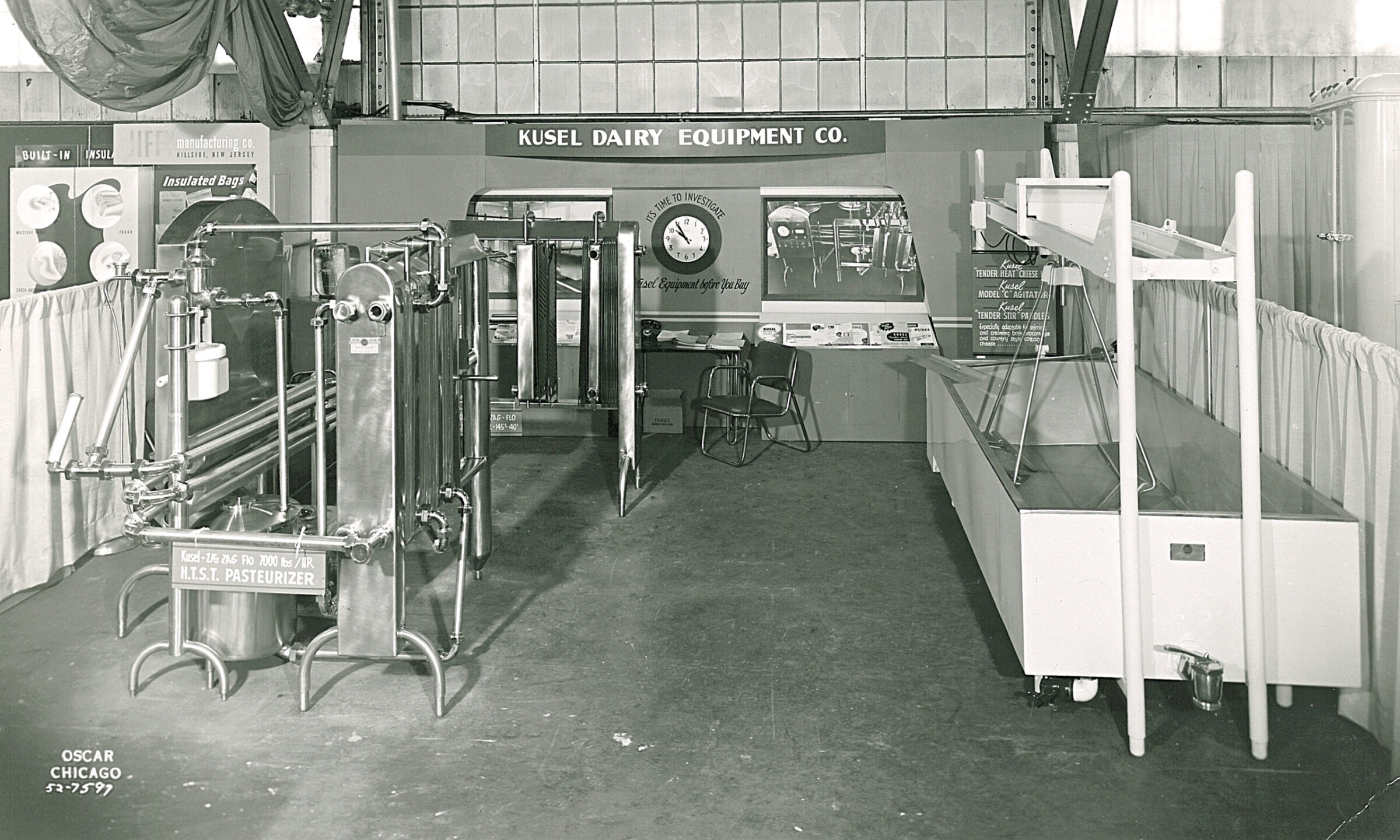 Kusel Dairy Equipment Co. exhibit with pasteurizer and large tank.