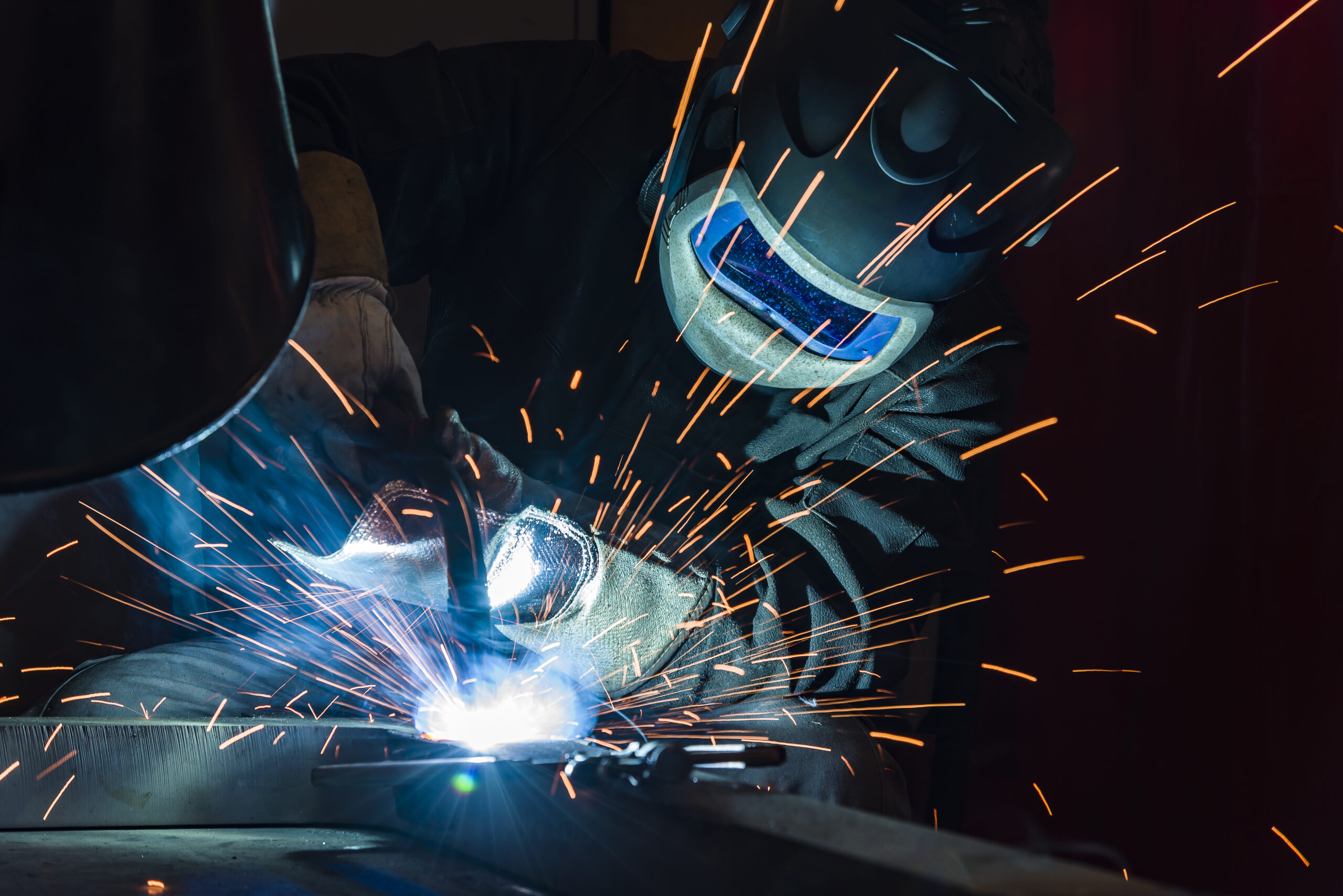 An Industrial steel welder welding with sparks flying