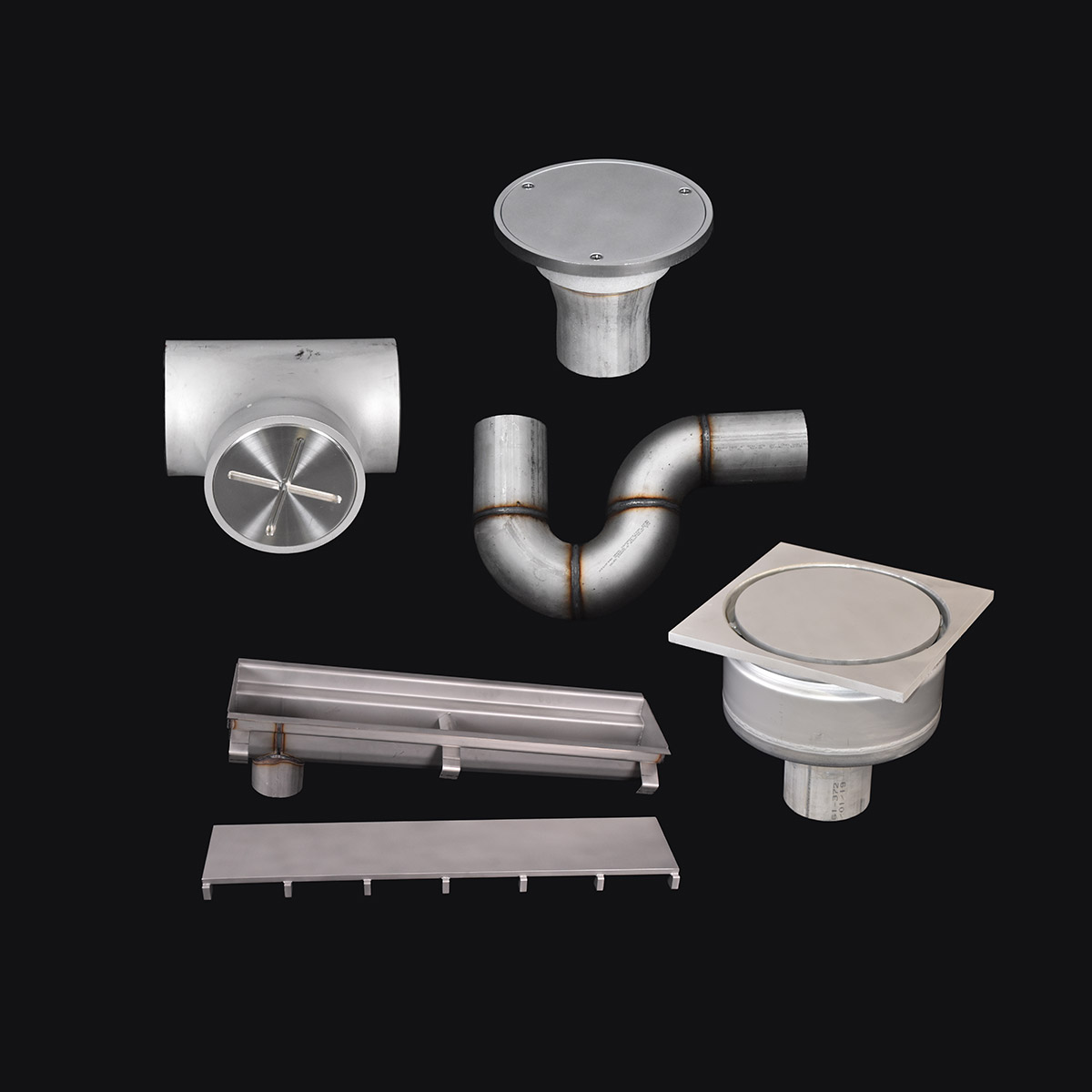 Various stainless steel plumbing components and drains on black background.